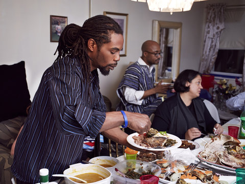 Man serving food at holiday dinner - Powered by Adobe