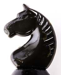black chess knight on a white background closeup © leitmotif425