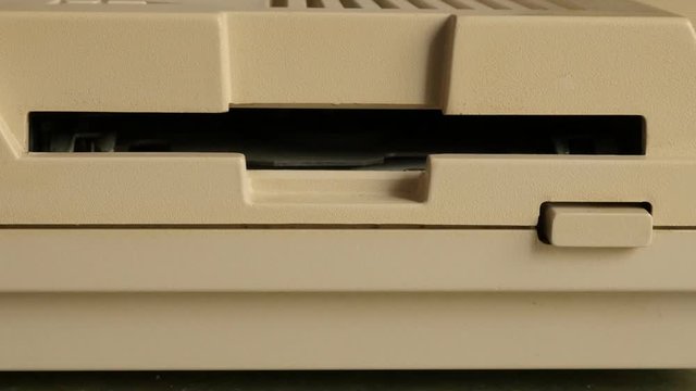 Floppy drive accepting and reading 3.5 inch pink diskette close-up 4K 2160p 30fps UltraHD video - Inserting 3.5 inch DD floppy disk in disk drive 4K 3840X2160 UHD footage 