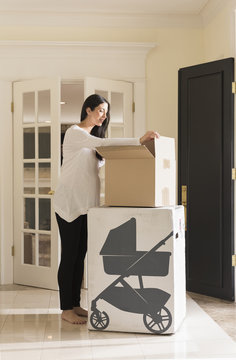 Pregnant Caucasian Woman Unpacking Baby Supplies