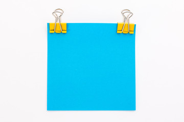 blue piece of paper with yellow paper clips