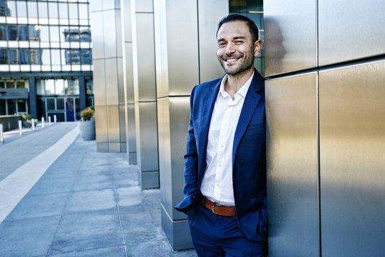 Caucasian businessman smiling outside office building