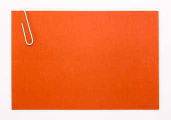 red sheet of paper with a white clip