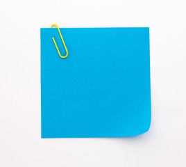 blue sheet of paper with yellow paper clip on a white background