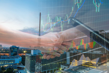 Double explosure with businesss charts , handshake and city of b