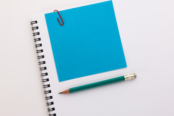 notebook blue piece of paper with a red paper clip and pencil