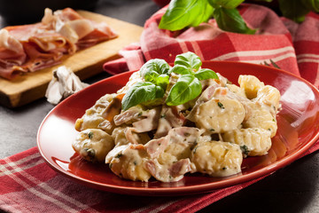 Potato gnocchi, Italian potato dumplings with cheese sauce, ham