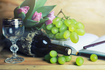wooden table with wine bottle book and grape
