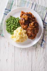 Salisbury steak with gravy, mashed potatoes and green peas. vertical top view    © FomaA