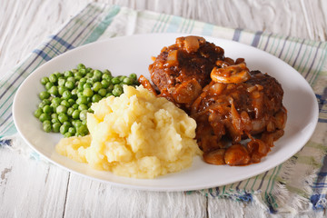 Salisbury steak with potatoes and green peas close-up on a plate. horizontal   © FomaA