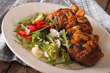Salisbury steak with vegetable salad close-up on a plate. horizontal
