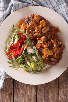Salisbury steak with mushroom sauce and vegetable close-up. vertical top view 
