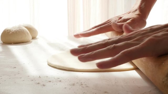 Wooden rolling pin on handmade dough on table 4K 3840X2160 30fps UHD footage - Rod type roller on hand kneaded dough 4K 2160p UltraHD video 