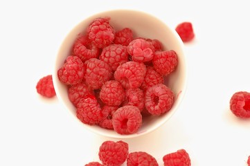 Raspberries in the bowl on the white background