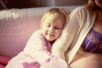 Fototapeta premium Mother and daughter hugging in a bedroom