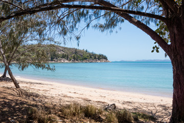 Beach and blue sea framed by trees on tropical Magnetic Island, Australia