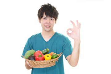 野菜を持つ笑顔の男性