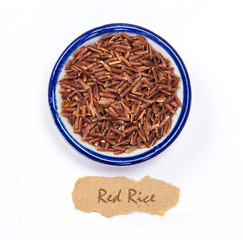 the organic  red rice in cup with name tag on white background