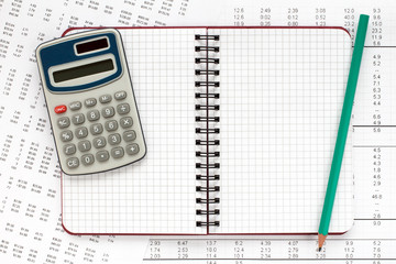 Calculator and notebook on financial statement.