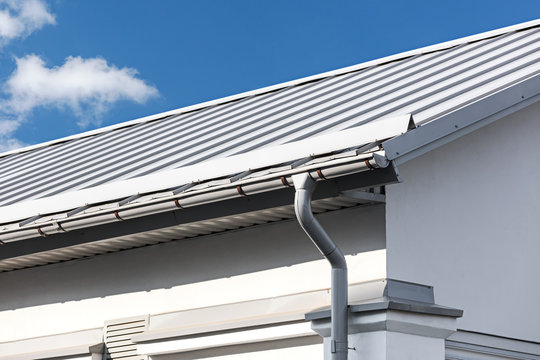 gray metal roof with gutter and drainpipe