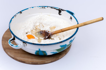 Raw egg in the flour with wooden scoop