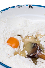 Raw egg in the flour with wooden scoop