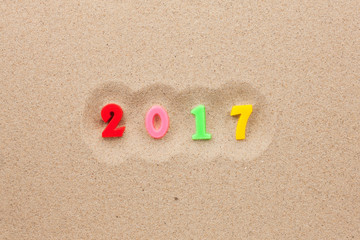 Fototapeta na wymiar New year 2017 written in the sand