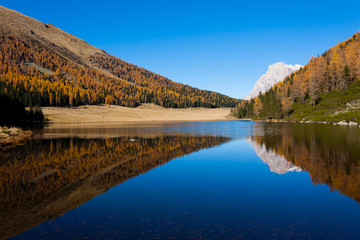 Reflections on water, autumn panorama from mountain lake