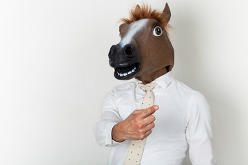 Businessman portrait wearing horse head and finger-pointing