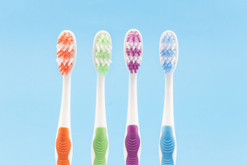 Colourful toothbrushes isolated on blue