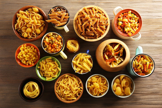 Various types of pasta in dishes, top view