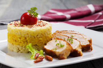 Portion of risotto with roasted chicken.