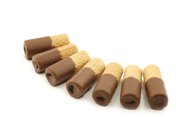 rolled up crispy chocolate wafers on a white background