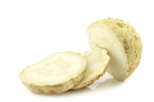 fresh celery root cut in slices on a white background