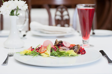 Russian Vinaigrette Salad Served on a Restaurant Table with a Glass of Fruit Juice