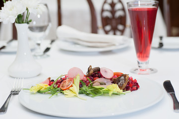Russian Vinaigrette Salad Served on a Restaurant Table with a Glass of Fruit Juice