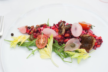 Vinaigrette Russian Salad made of chopped beets, carrots, onion, beans, peas, seasoned with...