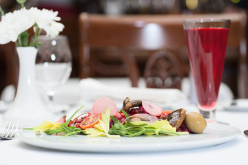 Russian Vinaigrette Salad Served on a Restaurant Table with a Glass of Fruit Juice