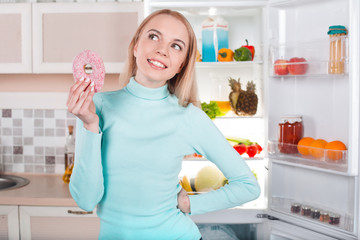 Young blonde at home near fridge