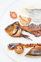 Smoked Fish Fillet with Smoked Onion and Smoked Fishbone served on a white plate