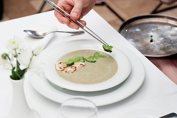 Process of eating a mushrooms cream soup with broccoli