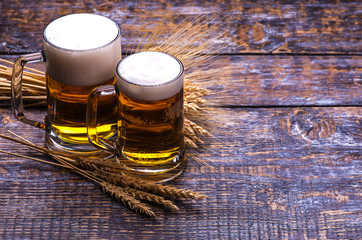 Beer light in a mug, ears of barley, wheat, isolated on wooden background