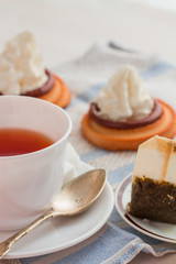 cup of tea with teaspoon and biscuit cakes