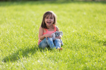 Fototapeta premium Sweet little girl outdoors playing
