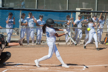 Filipino softball batter hitting a line drive. 