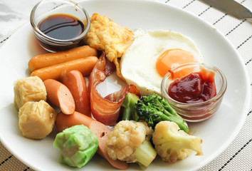 Fresh breakfast with sauce , fried egg, bacon , sausages , shuma