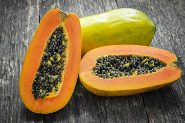 Slice of ripe papayas on wooden table