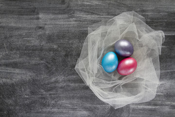 Colorful easter eggs on a blackboard. Top view with copy space