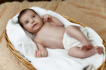 Cute newborn baby lying in wicker basket