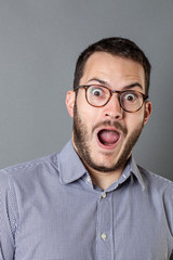 happy young bearded corporate man with mouth open to express surprise